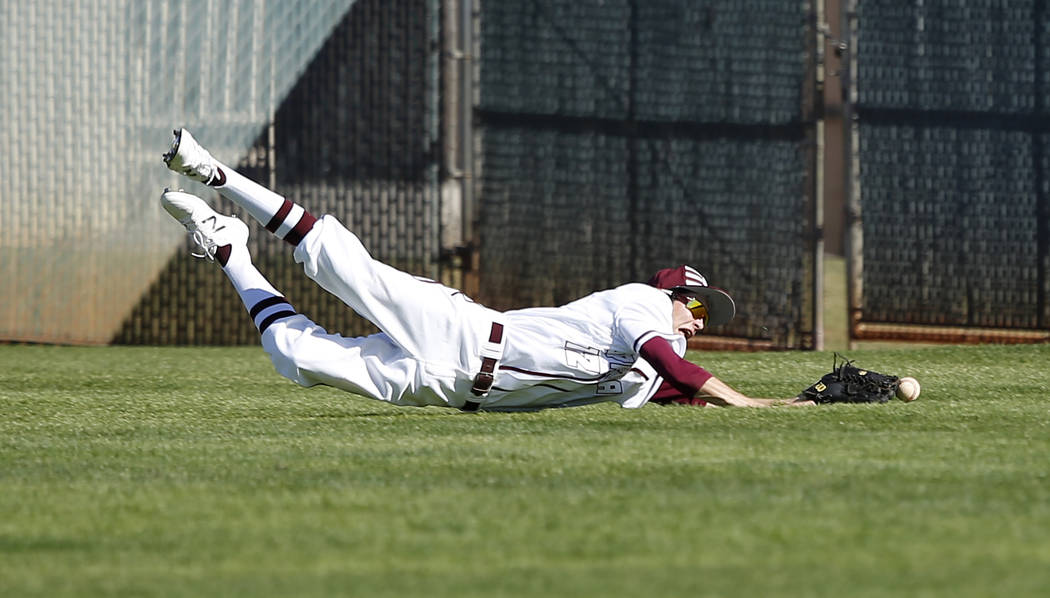 Cimarron-Memorial’s Jack Kannon (12) dives for the ball during a high school baseball ...