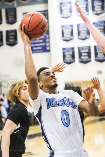 Centennial’s Troy Brown (0) slices to the rim past Faith Lutheran’s Nic Maccioni ...