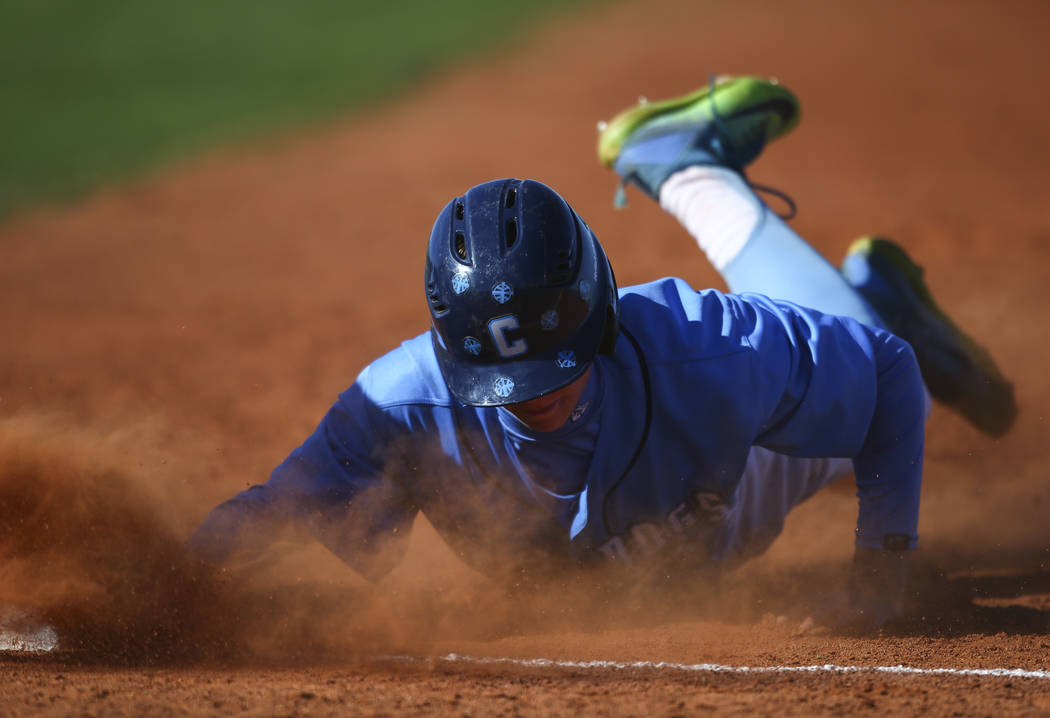 Centennial’s Kian Wilbur (4) slides back to first base to stay safe during a baseball ...