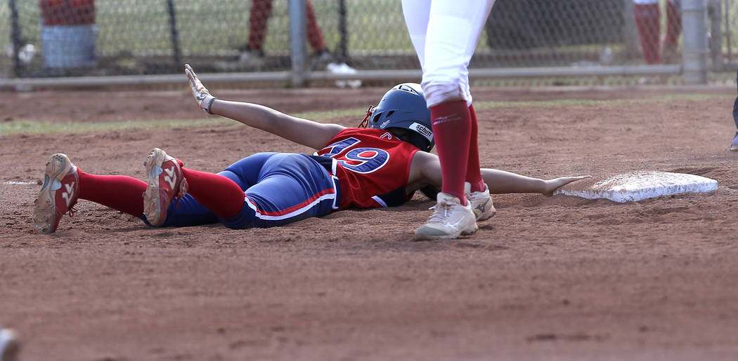 Liberty’s Alyssa Tolentino (19) dives for third base after attempting to steal during ...