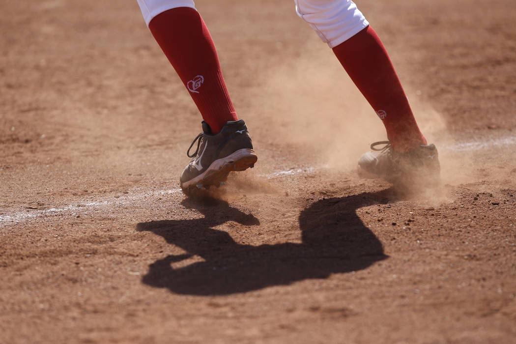 Dust flies as a player leads off third base during a high school softball game at Coronado H ...