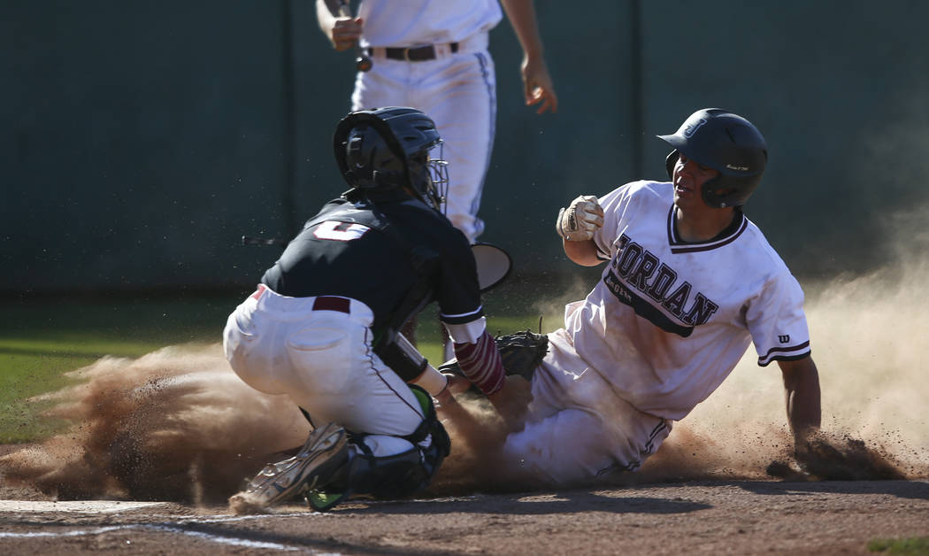 Jordan’s Hunter Swapp (28) gets tagged out by Desert Oasis’ Gage Ventura (6) at ...