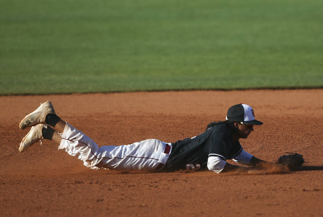 Desert Oasis’ Andrew Martinez (2) fields a grounder from Jordan during the Bishop Gorm ...