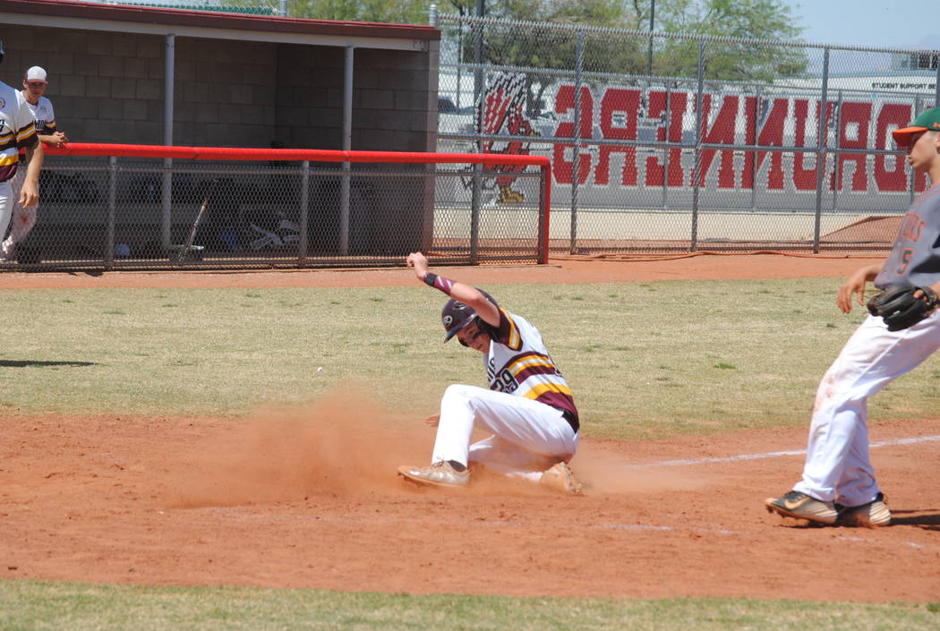 A Pahrump Valley player slides across the plate to score a run on Wednesday. The Trojans bea ...