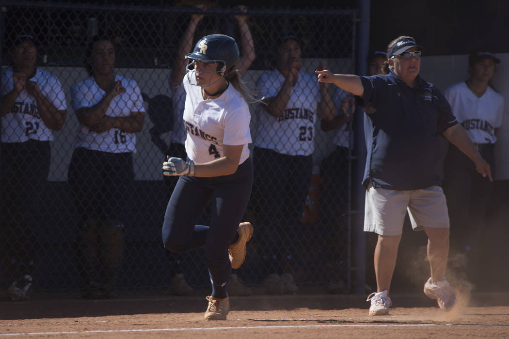 Shadow Ridge sophomore Shea Clements runs past her coaches and teammates into home during a ...