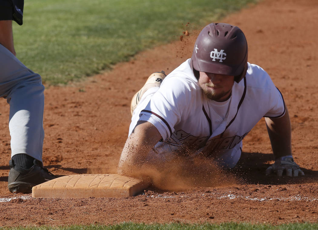 Cimarron-Memorial’s Kenny Wexler (20) dives for first base after leading off of it dur ...