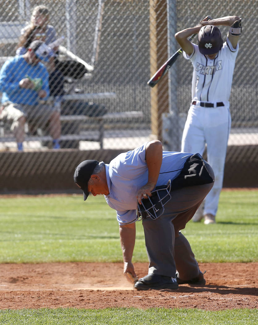 An umpire dusts off home plate as Cimarron-Memorial’s Jackson Folkman (6) approaches t ...
