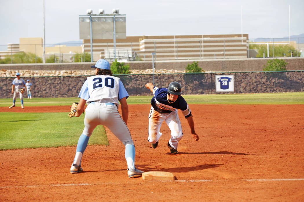 Spring Valley’s Jack Sellinger (17) prepares to dive for first base against Centennial ...