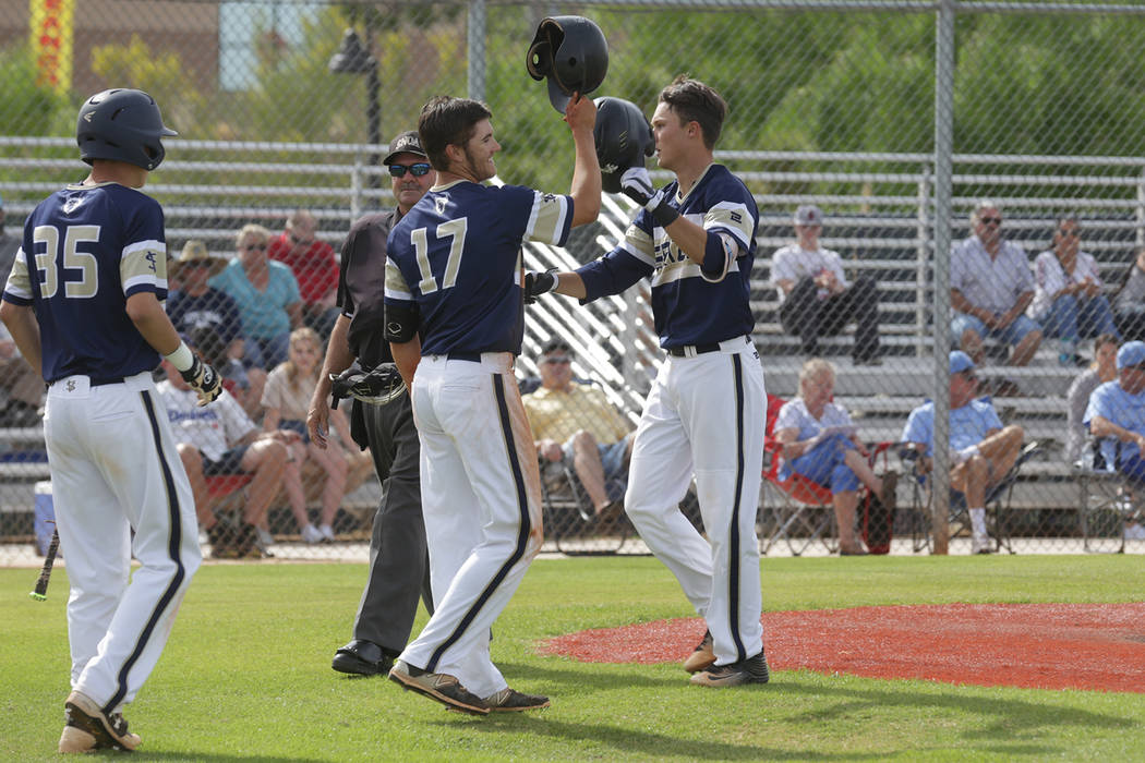 Spring Valley’s Bryce Bullock (41) high-fives teammate Jack Sellinger (17) after hitti ...
