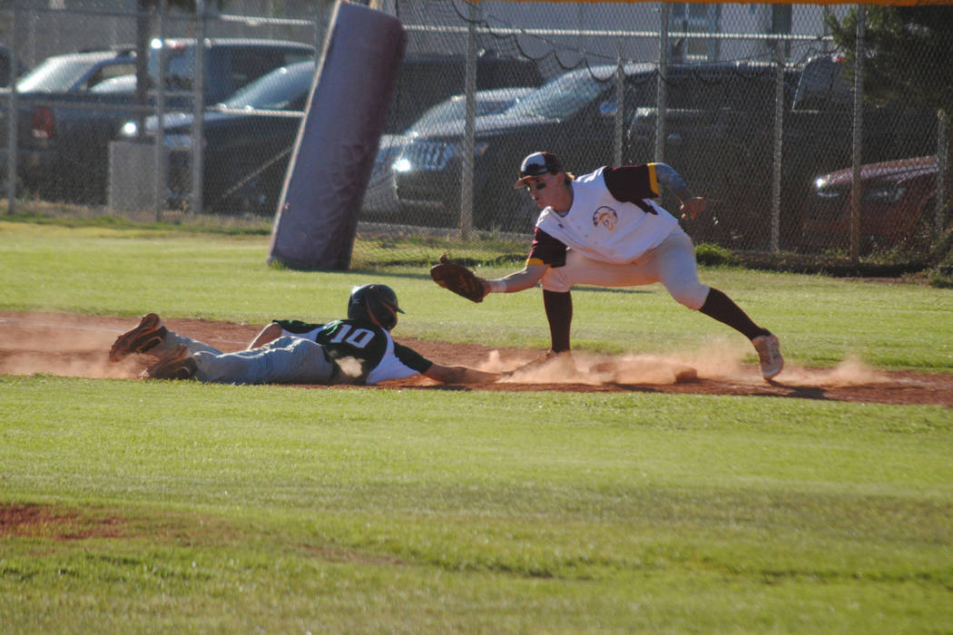 Mojave’s Scott Wilson dives safely back into first base as Pahrump Valley’s Park ...