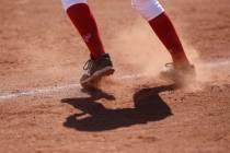 Dust flies as a player leads off third base during a high school softball game at Coronado H ...
