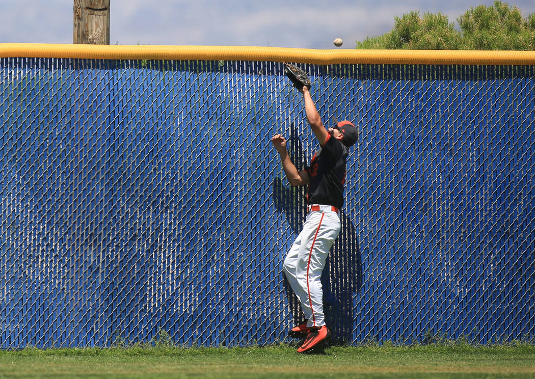 A home run ball sails over the fence, and head, of Bishop Gorman left fielder Ryan Sepede (1 ...