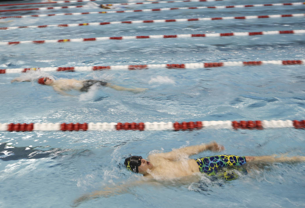 Faith Lutheran’s Michael Fisk , right, competes in the 200 yard individual medley duri ...