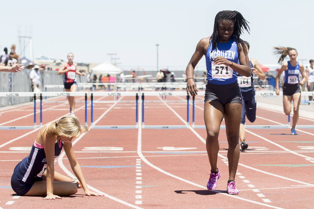 Centennial senior Talie Bonds falls to the ground next to McQueen junior Destiny Tolliver af ...