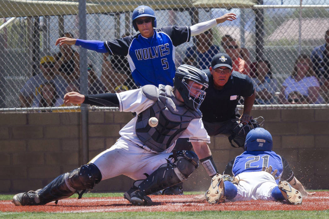 Basic’s Paul Myro, right, slides safely into home plate with the final run of a 16-6 w ...