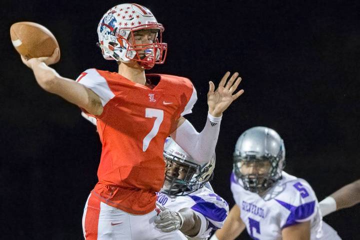 Liberty’s Kenyon Oblad (7) makes a pass with Silverado defenders on his back during th ...