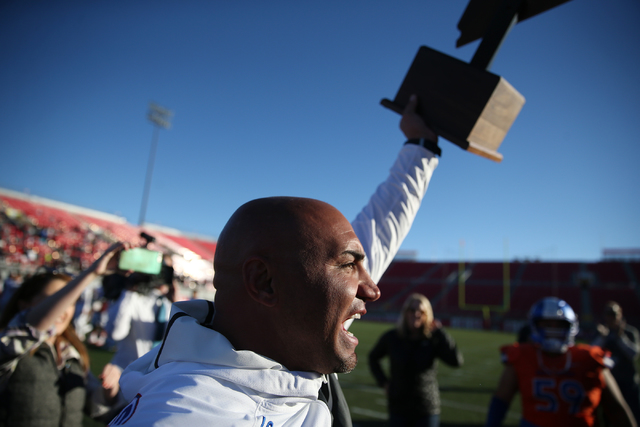 Bishop Gorman’s head football coach Kenny Sanchez lifts the champion after their 84-8 ...