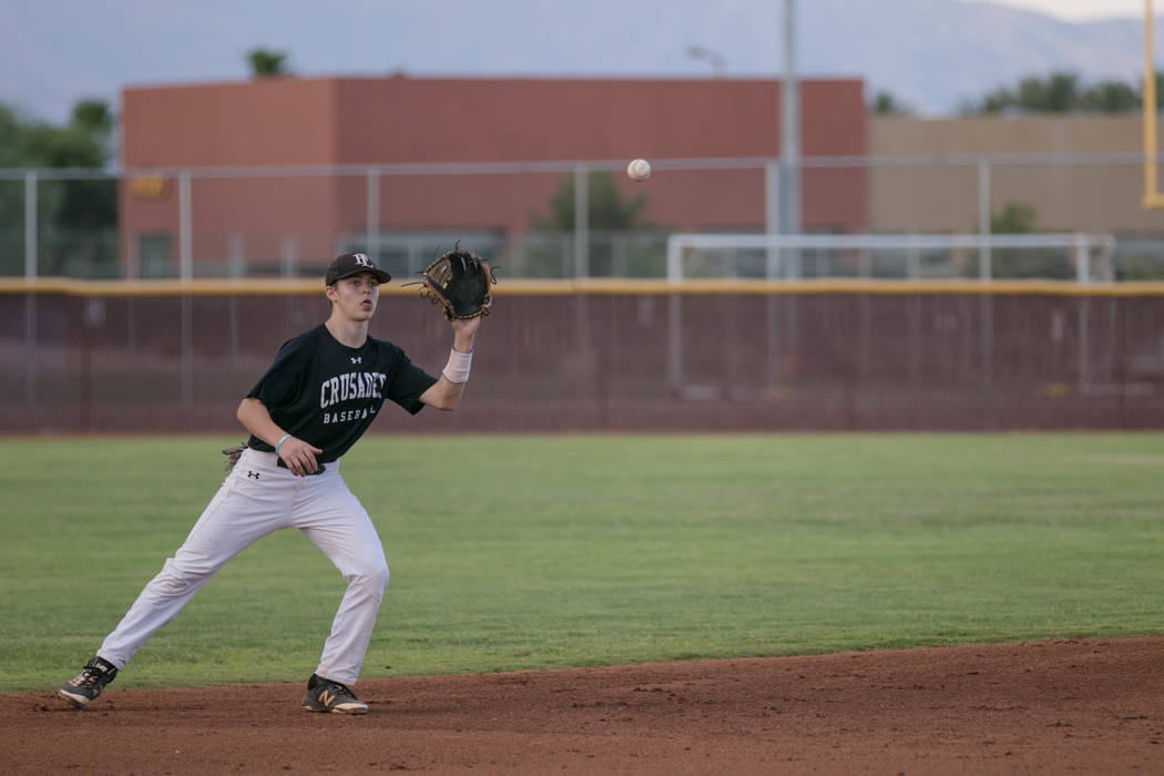 Faith Lutheran Crusader Paulshawn Pasqualotto eyeing the ball at shortstop during a game at ...