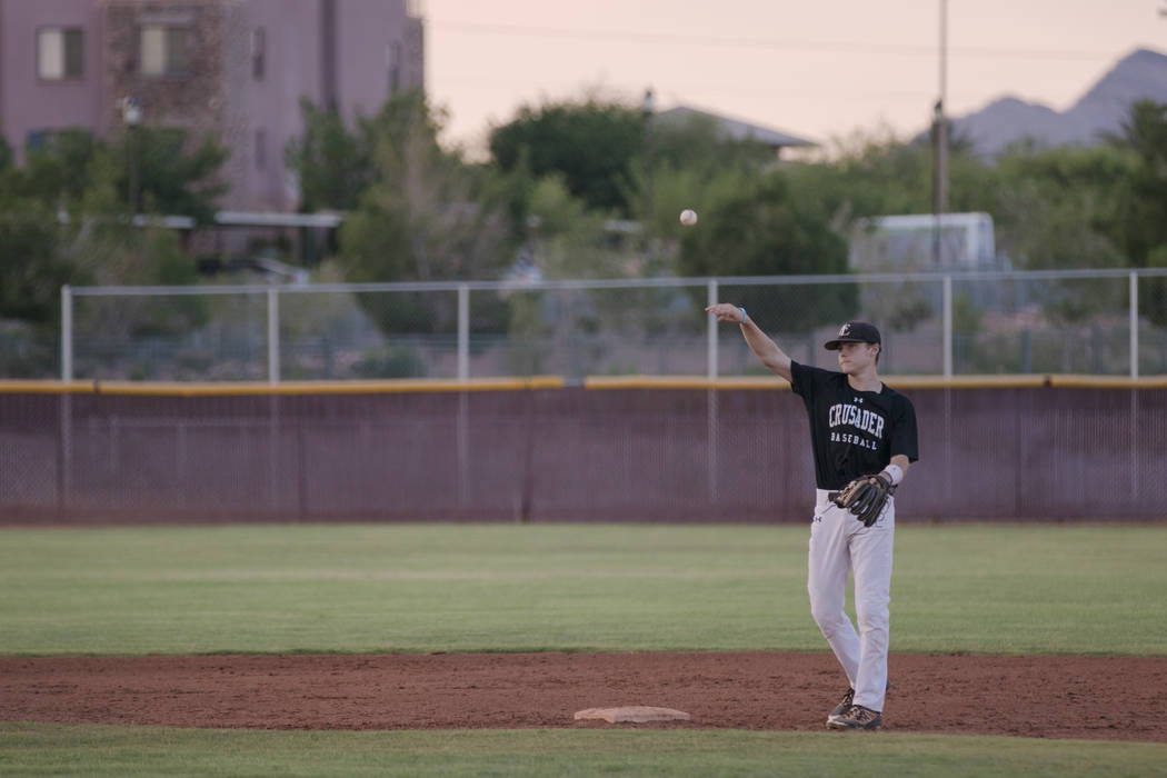 Faith Lutheran Crusader Paulshawn Pasqualotto tossing the ball to the pitcher during a game ...