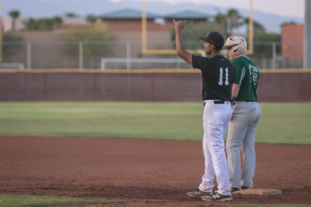 Faith Lutheran Crusader Jacob Ortega signaling a gameplan on first base, during a game at Fa ...