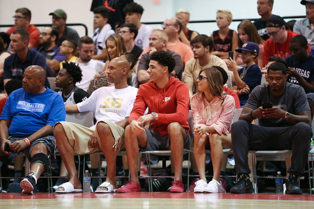 Lakers player Lonzo Ball, center, at courtside during an Adidas Summer Championship AAU tour ...