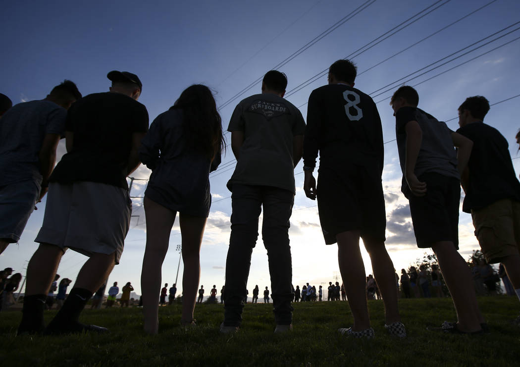 People stand in a circle during a vigil for Haylei Hughes, a former Cimarron-Memorial studen ...
