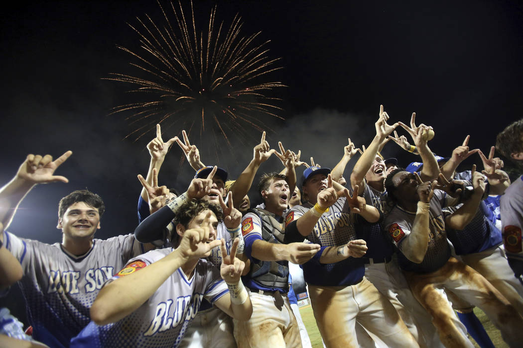Members of the Henderson, Nev., celebrate following their win in a baseball game against Oma ...