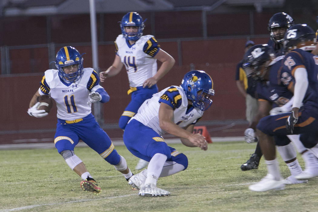 Moapa Valley’s Braeden St. John (11) runs the ball against Legacy High players during ...