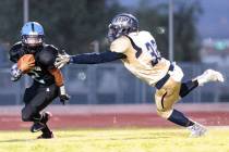 Cheyenne junior Clarence Rose (32) reaches out for Canyon Springs junior Diamante Burton (2) ...