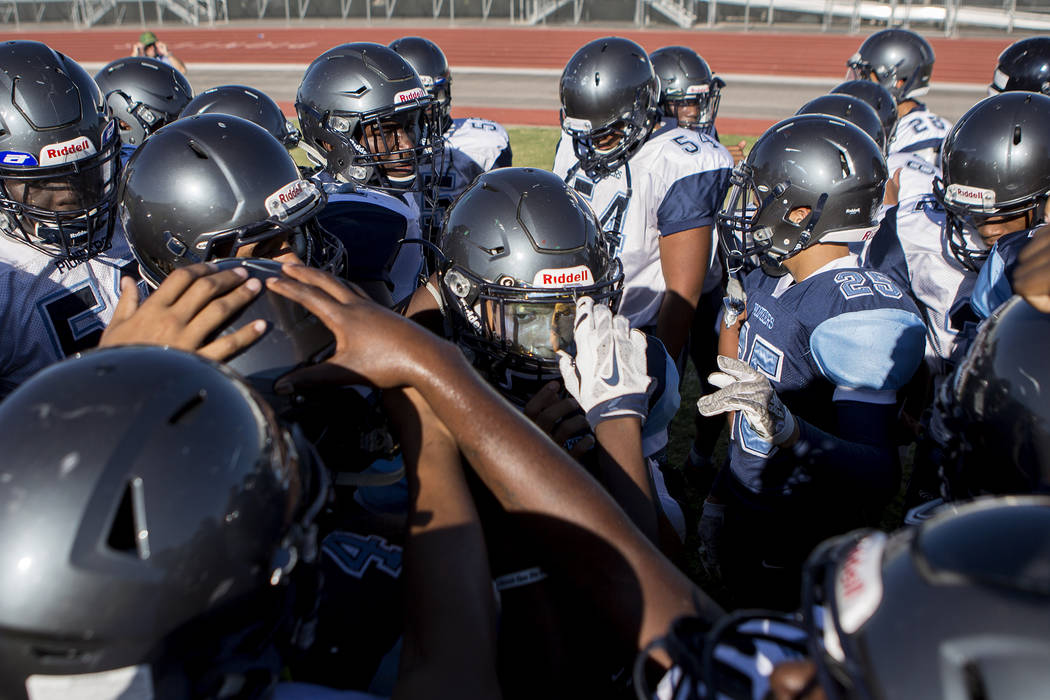 Canyon Springs football player Diamante Burton (2), center, huddles with teammates during pr ...