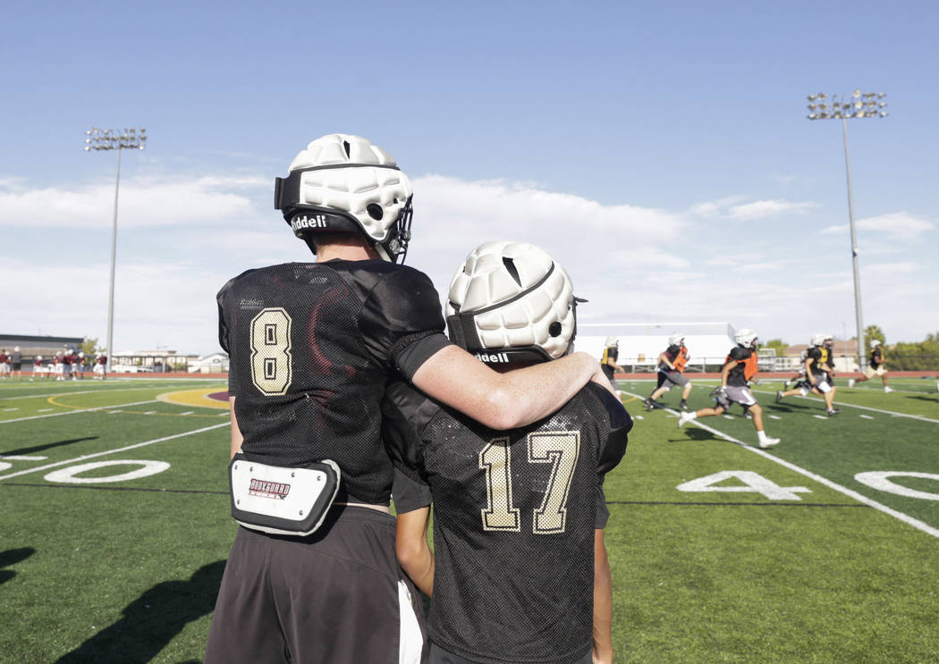 Faith Lutheran wide receiver Elija Kothe (8), left, puts his arm around wide receiver and co ...