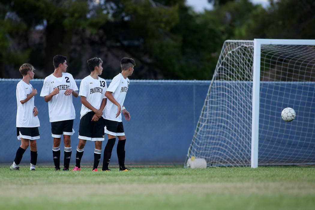 Palo Verde players watch as a Faith Lutheran player kicks a free kick at their goal during a ...