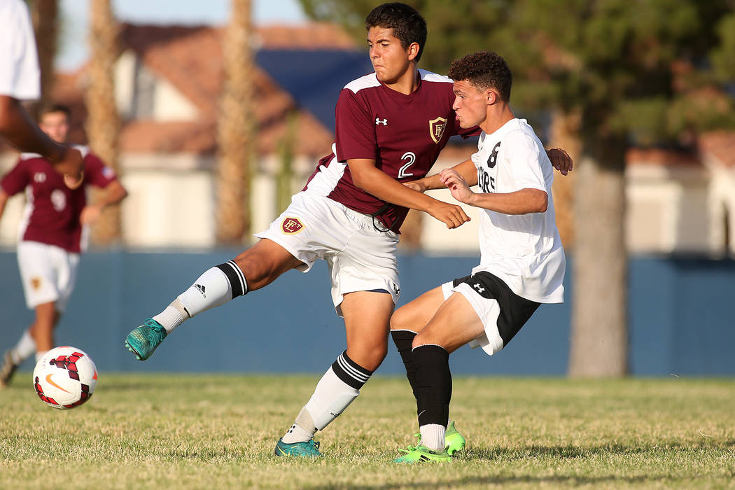 Faith Lutheran player Angel Mange, left, and Palo Verde player Michael Vogel fight for the ...