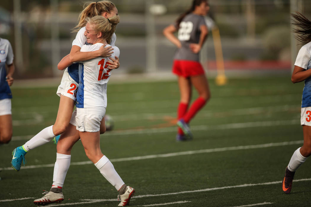 Bishop Gorman’s Jacqueline Hillegas, 23, is embraced by Kevyn Hillegas, 12, after scor ...