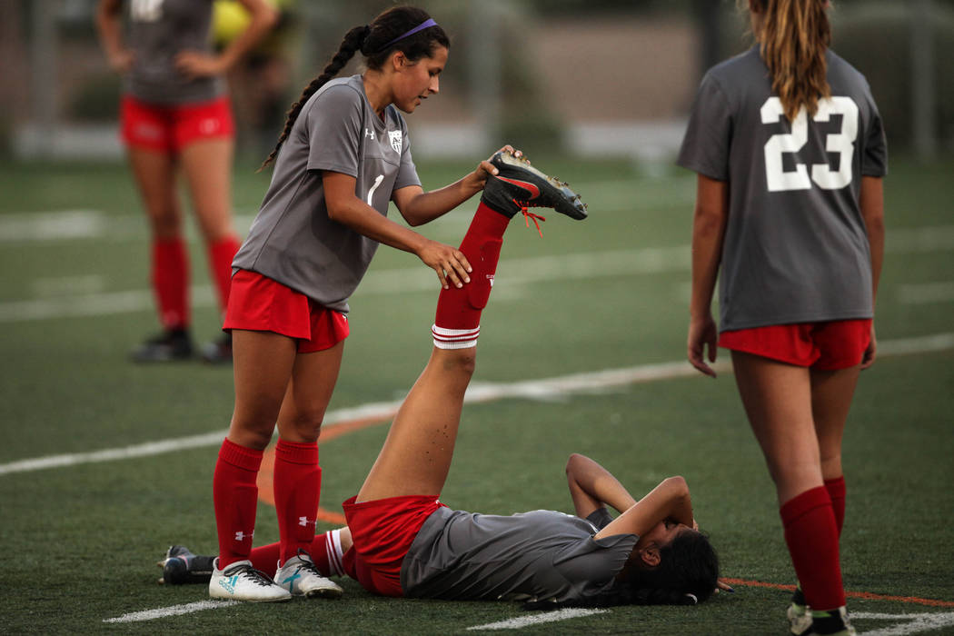 Arbor View High School’s Sierra Vicente, 1, helps her teammate Karissa Martinez, 21, a ...