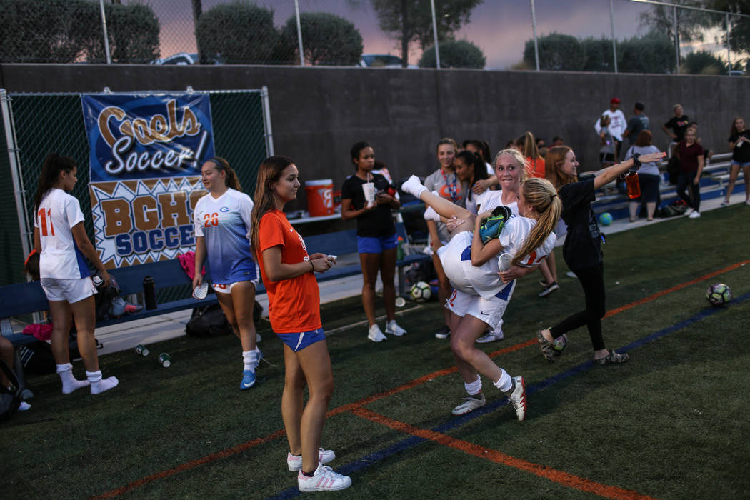 Bishop Gorman’s Jacqueline Hillegas, 23, is carried by Kevyn Hillegas, 12, at the end ...