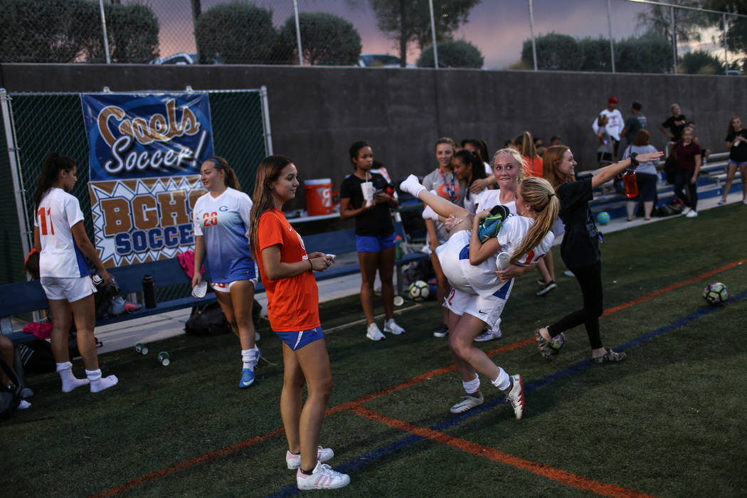 Bishop Gorman’s Jacqueline Hillegas, 23, is carried by Kevyn Hillegas, 12, at the end ...