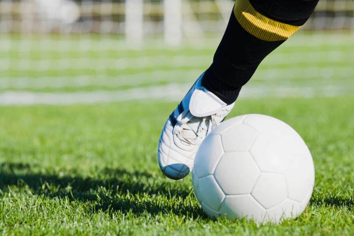 Low section view of a soccer player kicking a soccer ball