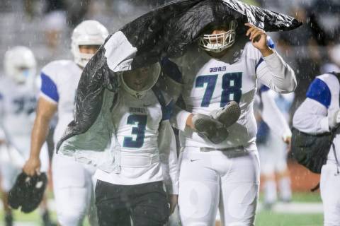 Green Valley’s Christian Mayberry (3), and Eric Brown (78) leave the field due to a we ...