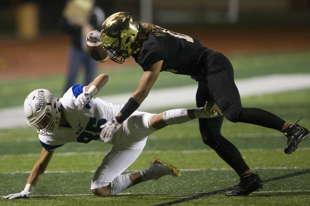 Faith Lutheran’s Taimani McKenzie (10) deflects a pass to Green Valley’s Adrian ...