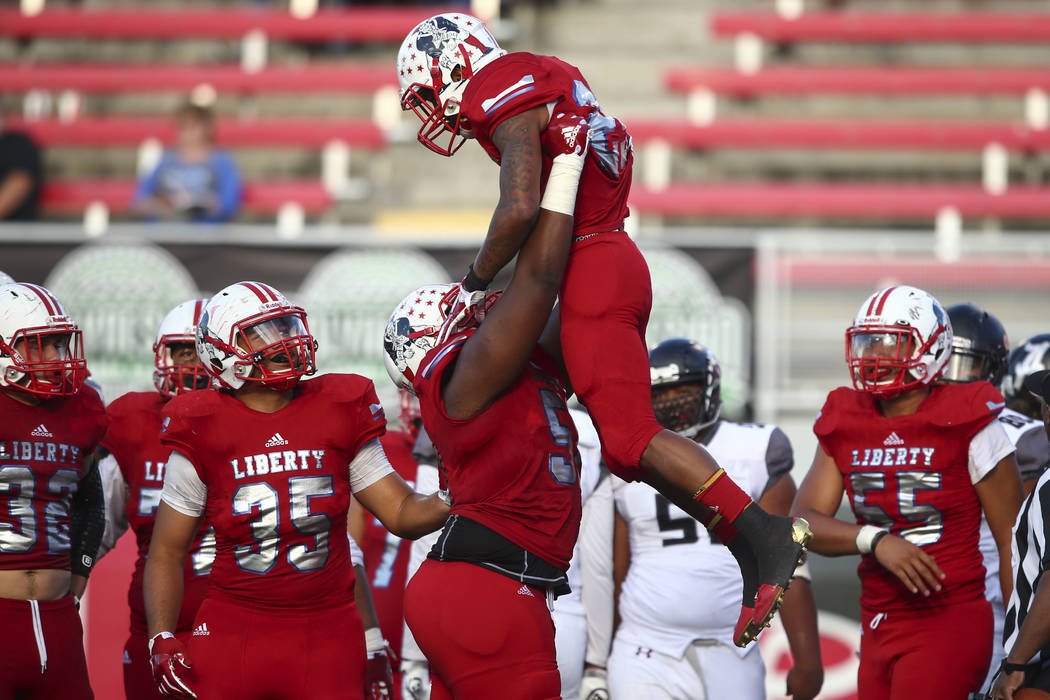 Liberty’s Syvone Sistrunk (51) lifts up Liberty’s Kishon Pitts (25) after a touc ...