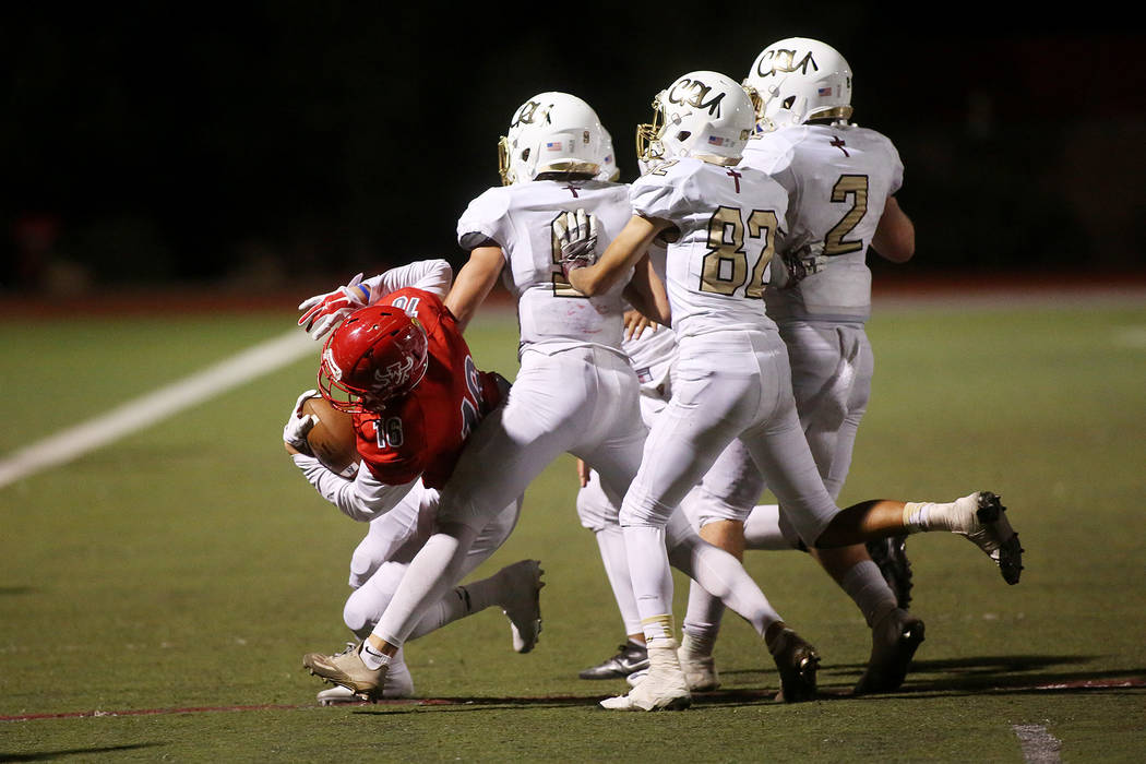 Faith Lutheran players attempt to tackle Arbor View player Nathan Egbalic during the second ...