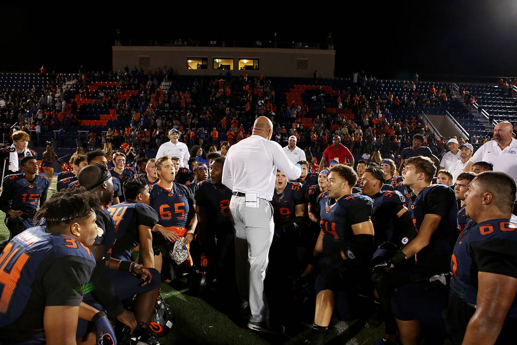 Bishop Gorman head coach Kenny Sanchez, center, talks to players after their 34-7 win over D ...