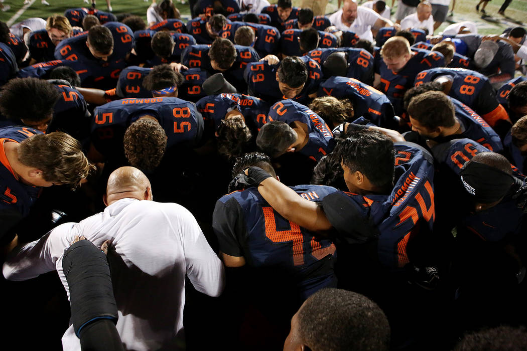 Bishop Gorman players say a prayer after their 34-7 win over De La Salle at Bishop Gorman Hi ...