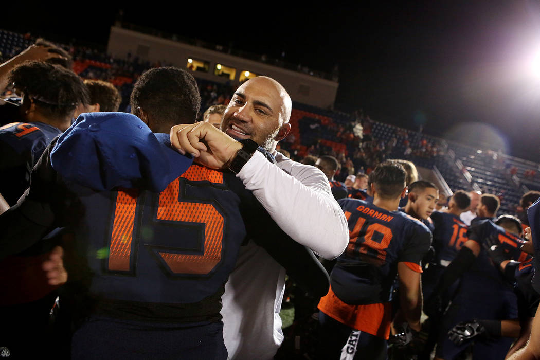 Bishop Gorman head coach Kenny Sanchez embraces Kyu Kelly (15) their 34-7 win over De La Sal ...