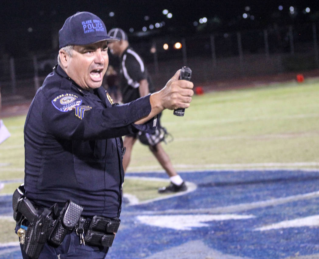 A police officer holds pepper spray after dispersing a brawl between Canyon Springs and Basi ...
