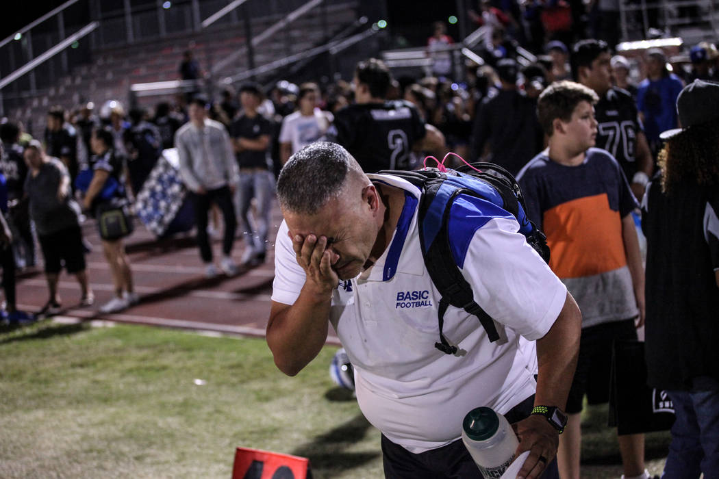 A Basic football staff member flushes his eyes after being pepper sprayed by a police office ...