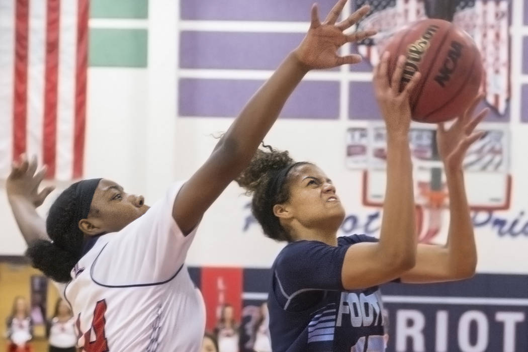 Foothill’s Rae Burrell (12) drives past Liberty’s Dre’una Edwards (44) dur ...