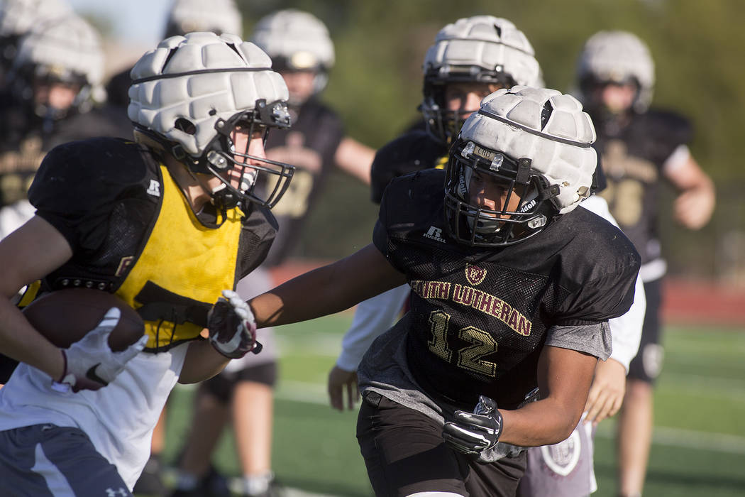 Faith Lutheran football player Ma’a Gaoteote, right, runs plays with teammates during ...