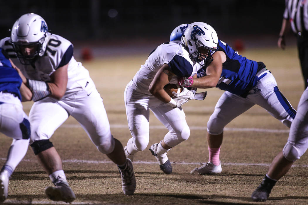 Foothill’s Issac Oliva (5), center, is tackled by Basic during the first quarter of a ...